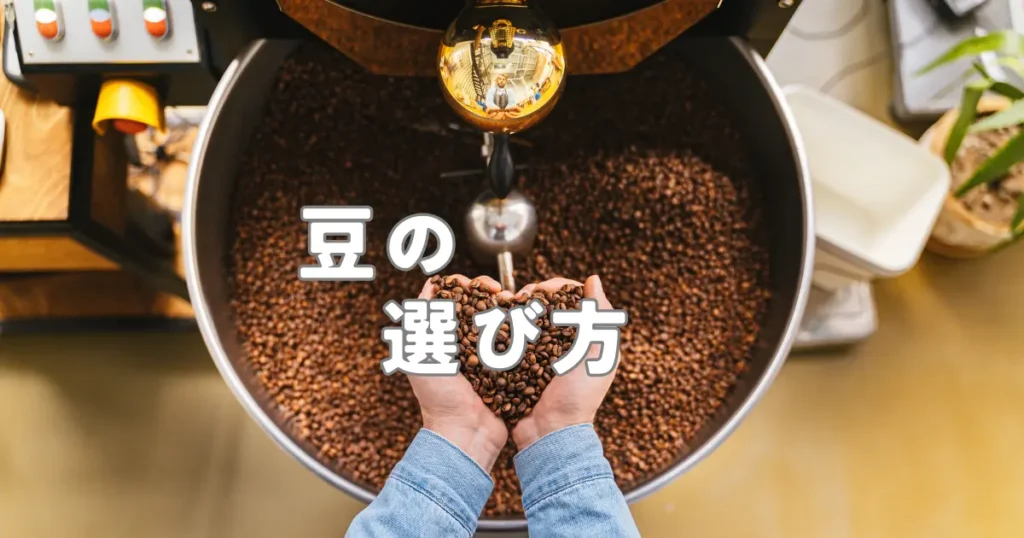 焙煎機いっぱいのコーヒー豆を手で持ち上げている様子を写した、豆の選び方の見出し画像